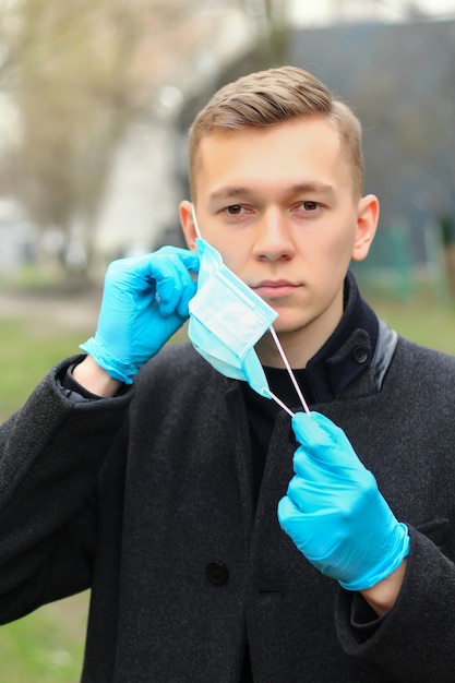 Attractive man removes a medical mask.