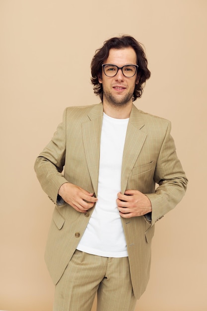 Attractive man spectacled beige suit elegant style beige background. High quality photo