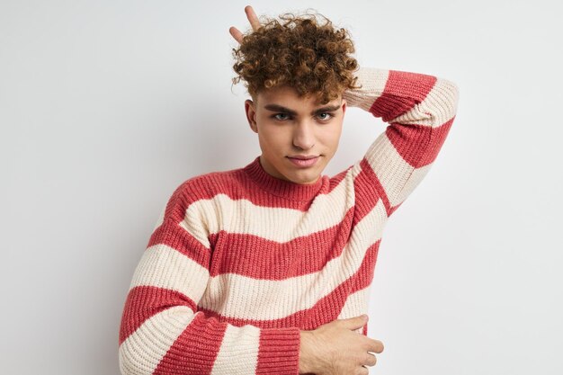 Attractive man in a striped sweater posing light background