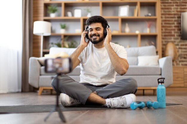 Attractive man using headphones while working out at home