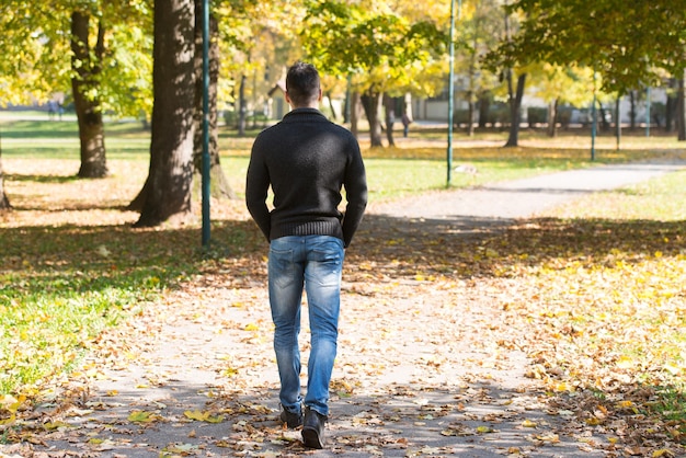 Photo attractive man walking in autumn forest