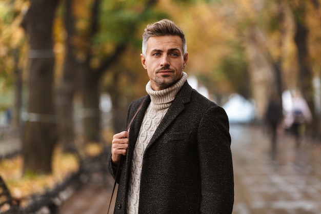 Attractive man wearing jacket walking outdoors