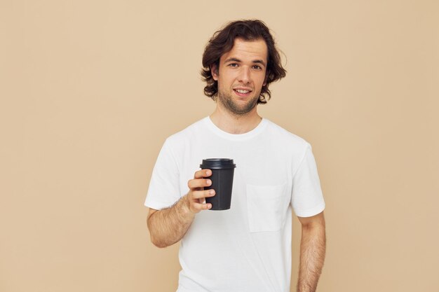 Attractive man in a white Tshirt with a black glass in hand Lifestyle unaltered