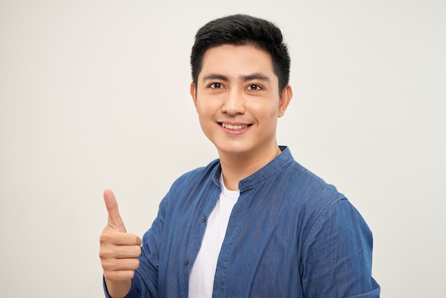 Photo an attractive man with a big smile on his face, doing a thumbs up against a camera