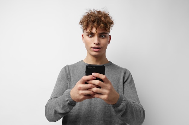 Attractive man with a phone in hand communication light background