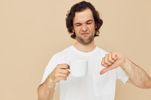 Attractive man with a white mug in his hands emotions posing isolated background