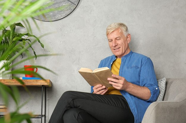 Photo attractive mature man reading book indoors