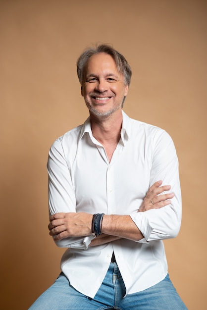 attractive mature man with beard on plain background wearing casual