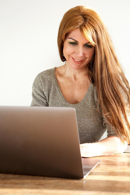 Attractive mature woman working on laptop