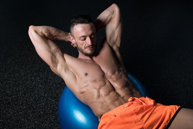 Attractive Men Doing SitUps With Exercise Ball