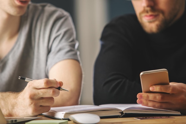 Photo attractive men using smartphone at workplace