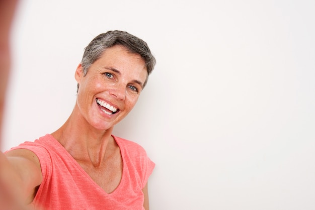 Attractive middle age woman smiling and taking selfie