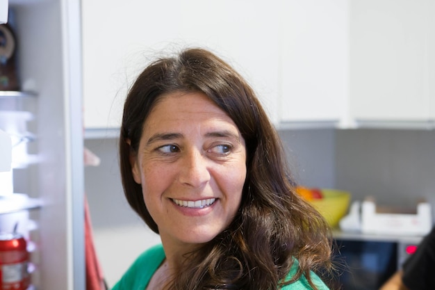 An attractive middleaged woman looking to the side smiling in the house