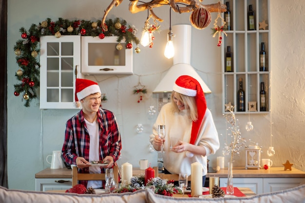 Attraente donna di mezza età e ragazzo preparano la tavola per la cena di natale madre e figlio