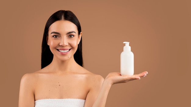 Attractive millennial halfnaked brunette woman recommending body cream or lotion