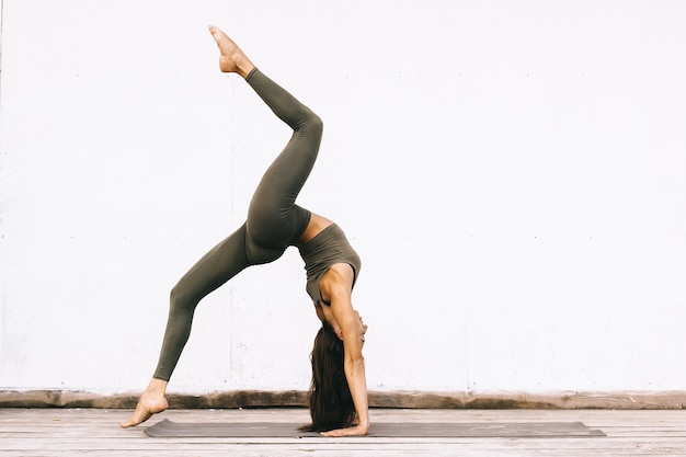 Attractive model in yoga pose on white background in sexual clothes