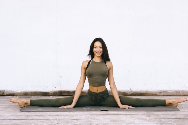 Photo attractive model in yoga pose on white background in sexual clothes