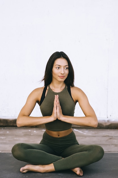 Attractive model in yoga pose on white background in sexual clothes