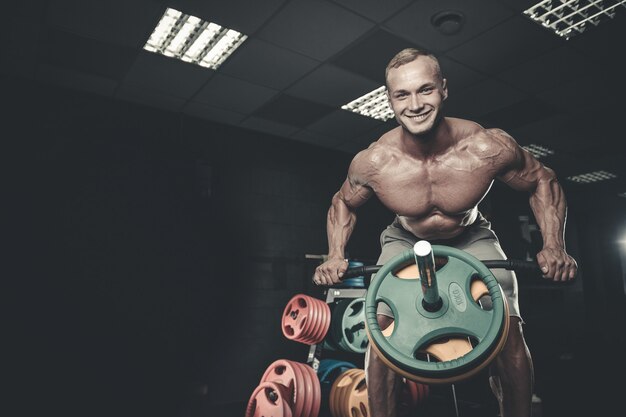 Foto addestramento di modello attraente del giovane in palestra