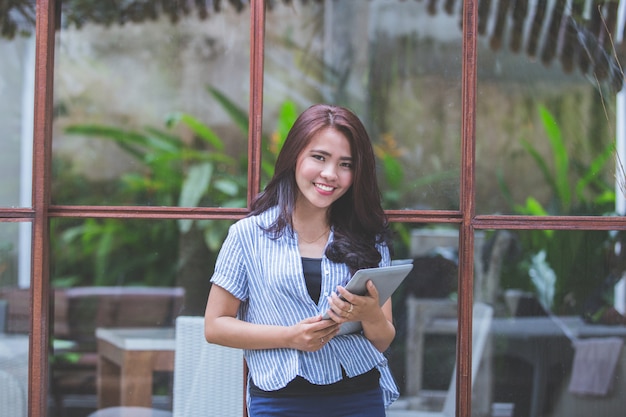 Attractive modern woman smiling with tablet