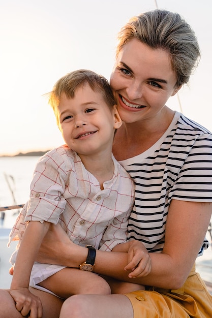 매력적인 어머니와 그녀의 사랑스러운 유아 아들이 선박으로 바다를 항해하고 있습니다.