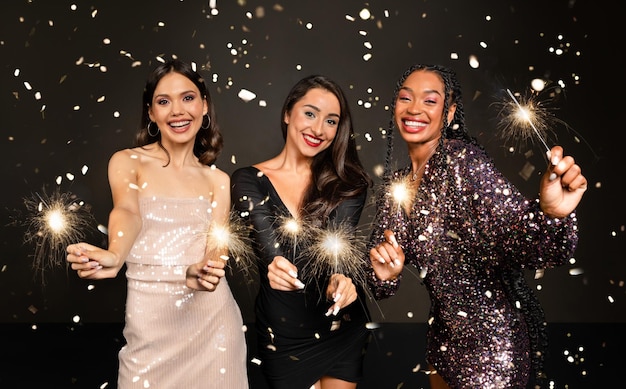 Attractive multiethnic young women friends celebrating new year together