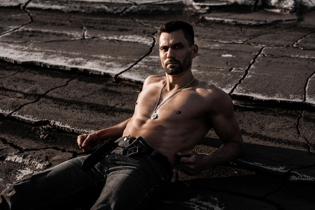 Attractive muscular man in black jeans at the ash dump.