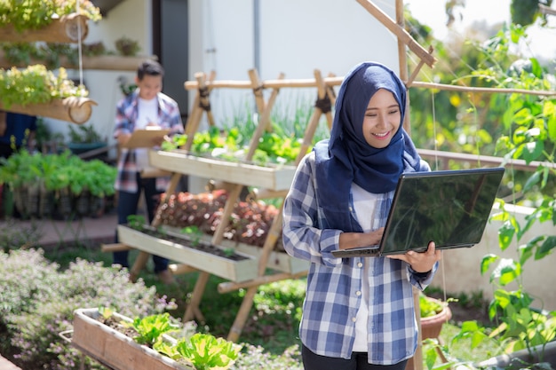 Attractive muslim woman with laptop in the farm