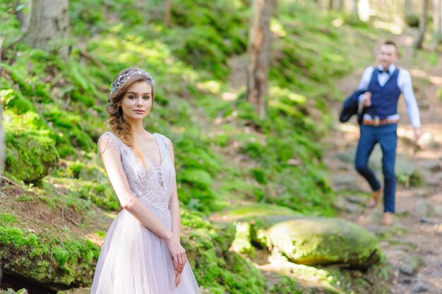 An attractive newlywed couple, a happy and joyful moment.  Bohemian-style wedding cermonia in the forest in the fresh air.