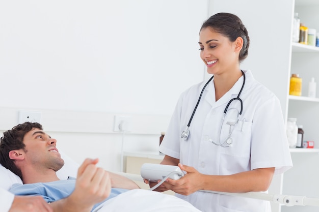 Attractive nurse measuring the blood pressure of a patient