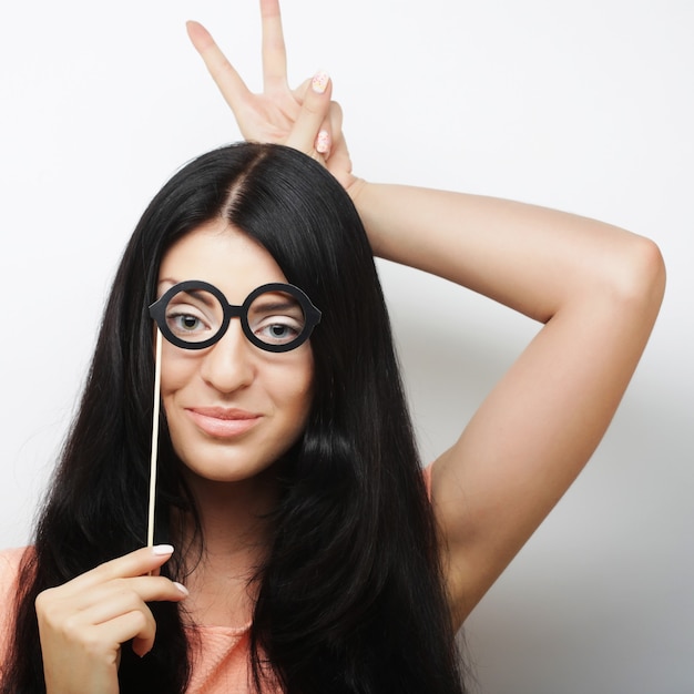 Attractive playful young woman with false glasses