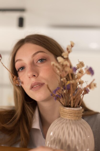 Attractive portrait of a blogger with dried flowers closeup