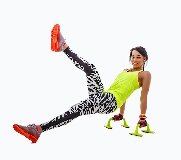 Attractive positive, flexible fitness woman doing legs exercises isolated on white background.