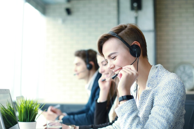 Attractive positive young businesspeople and colleagues in a call center office.