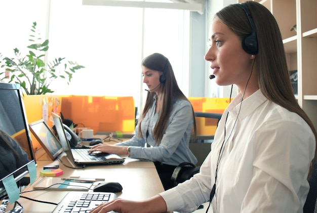 Photo attractive positive young businesspeople and colleagues in a call center office.