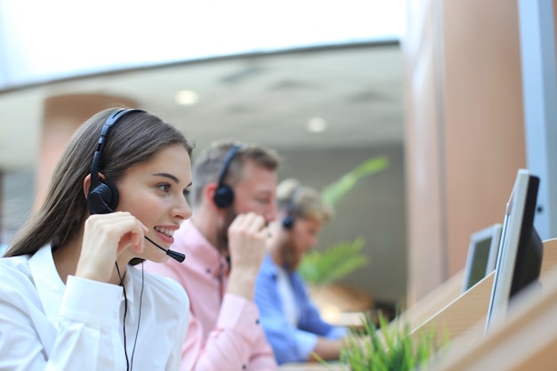 Attractive positive young businesspeople and colleagues in a call center office.