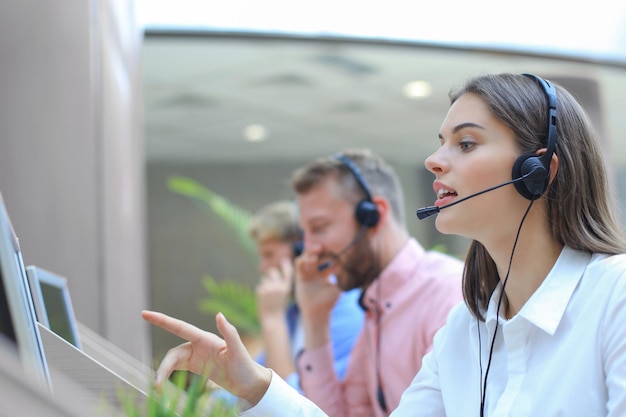 Attractive positive young businesspeople and colleagues in a call center office