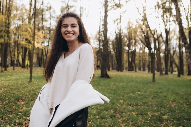 Photo attractive pretty woman walking outdoor portrait of young lady in warm sunny autumn park