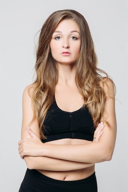 Attractive pretty woman wearing sports wear posing with  crossed arms.