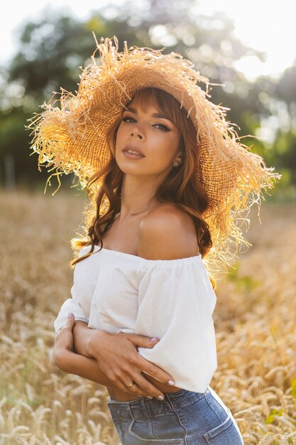 Привлекательная рыжеволосая девушка в пшеничном поле