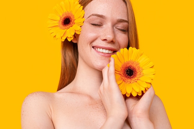 Attractive red-head female with bright flower