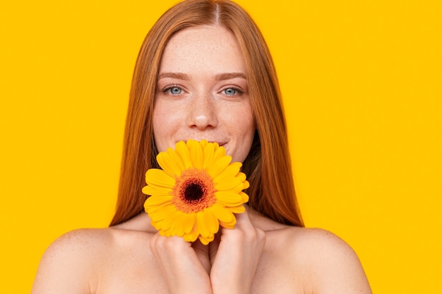 Attractive red-head female with bright flower