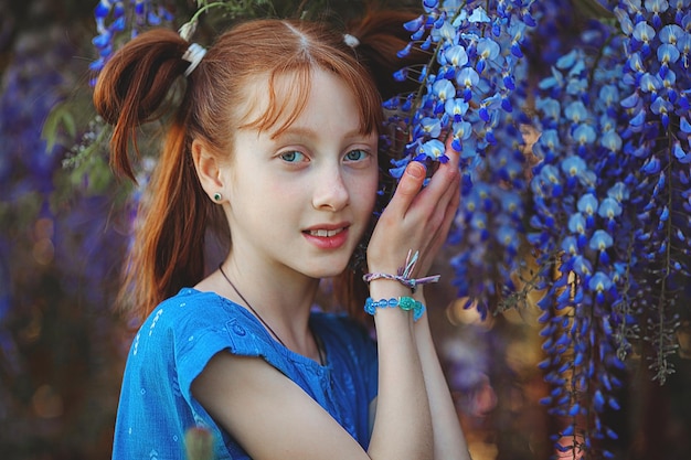 Attractive redhaired teen portrait Little girl with flowers