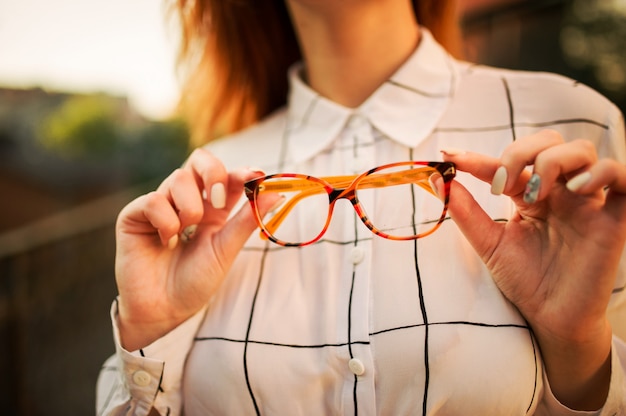 Attractive redhaired woman in eyeglasses wearing on white blouse 