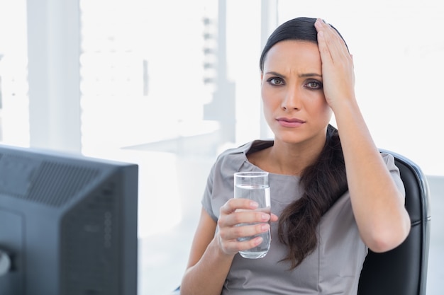 Attractive secretary with headache touching her head