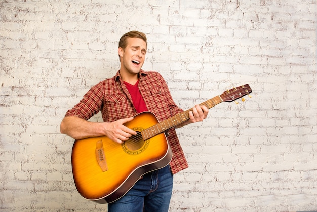 Attractive singer giving concert and playing on the guitar