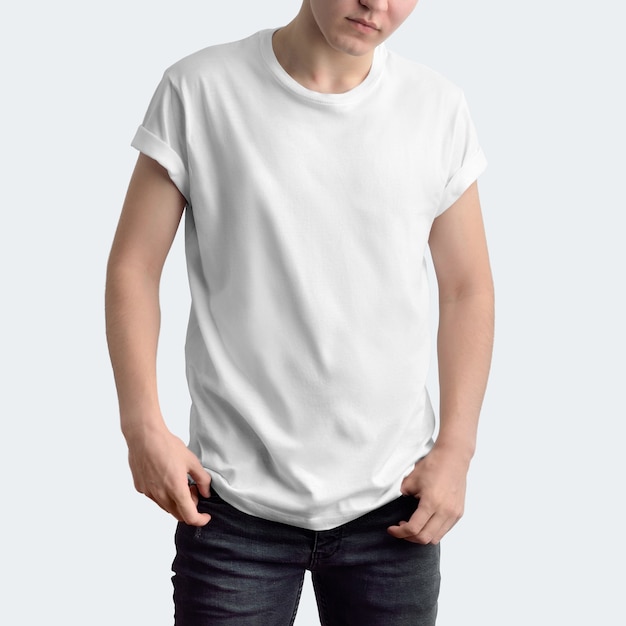 attractive slim guy in a blank t-shirt and dark jeans on a white studio background. frontal pose. 
mockup can be used in your showcase.