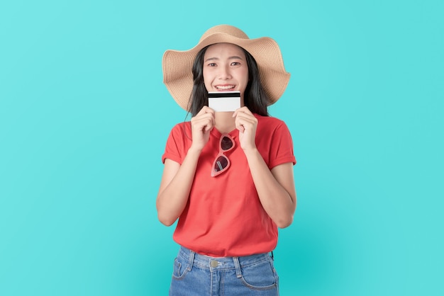 Attractive smile Asian woman holding credit card payment on blue .