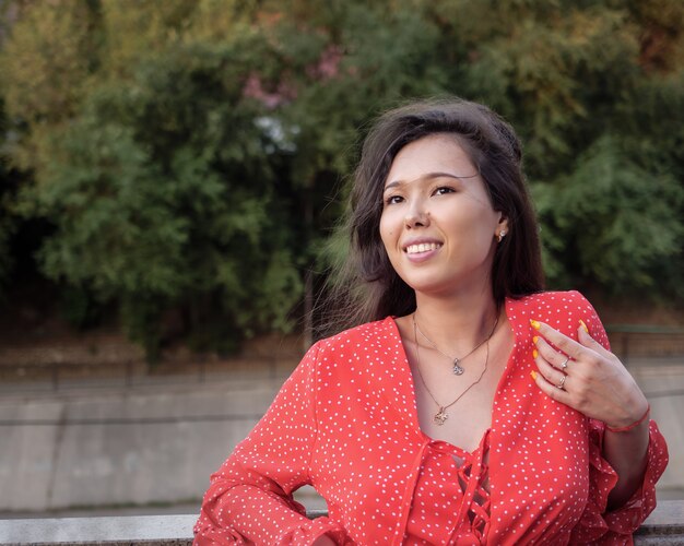 Attractive smiling Asian girl in red is smiling.