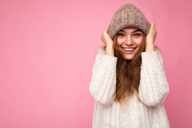 Attractive smiling happy young brunet woman standing isolated over colorful background wall wearing